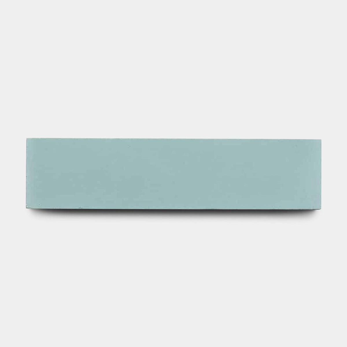 A sample of vendor-unknown's Sky Blue 2x8 tile is centered against a plain white background, its smooth finish echoing the look of a rectangular, light blue eraser.
