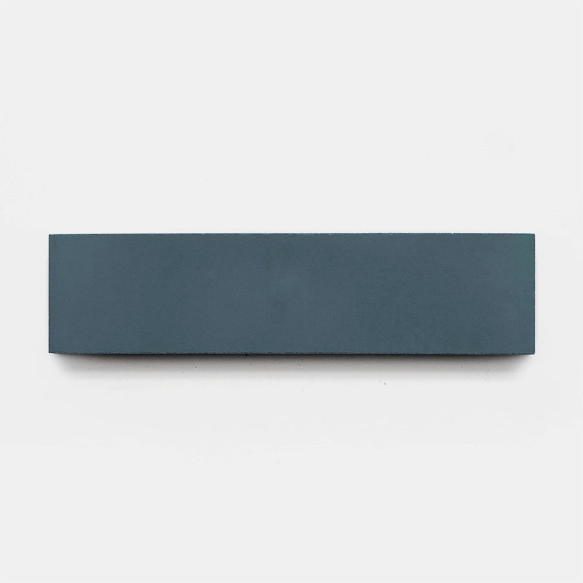 A rectangular Saddle 2x8 tile sample by Zia Tile in dark gray is shown horizontally on a plain white background.