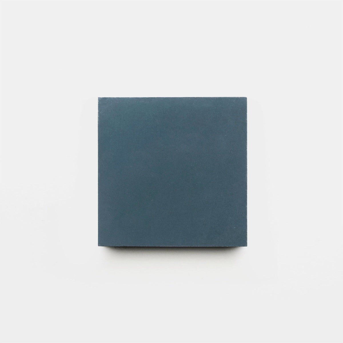 A single Steel 4x4 matte dark blue handmade tile sample by Zia Tile is centered on a white background.