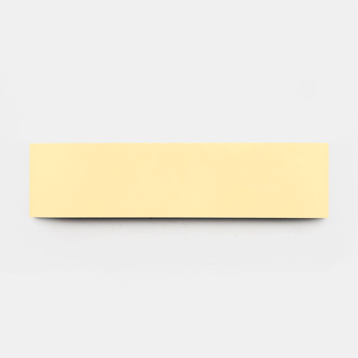 A rectangular, light yellow sticky note, inspired by the clean lines of vendor-unknown's Solar 2x8 sample tile, is centered on a plain white background. The blank note is shown from above.