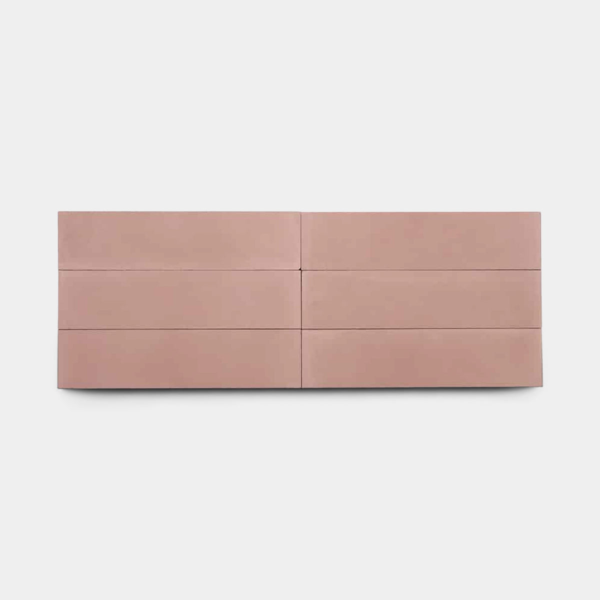 A modern, minimalist blush-pink dresser with six drawers sits on a white background, its sleek design effortlessly complementing Zia Tile’s Bonsai 2x8 Sample.