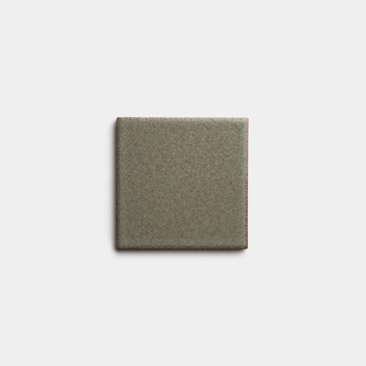 The Spanish Moss 4x4 by Zia Tile is a single square ceramic tile in muted olive-green with slightly darker edges, shown on a plain light gray background.