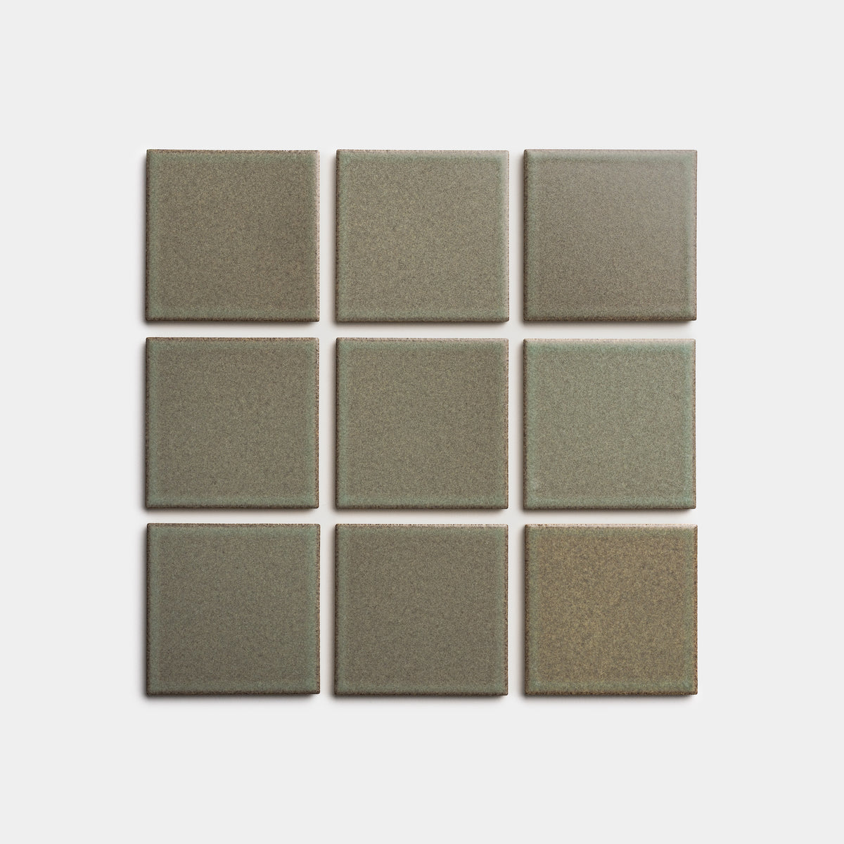 Nine Spanish Moss 4x4 ceramic tiles by Zia Tile, olive-green with a matte finish and subtle tonal variations, are arranged in a 3x3 grid on a plain white background.