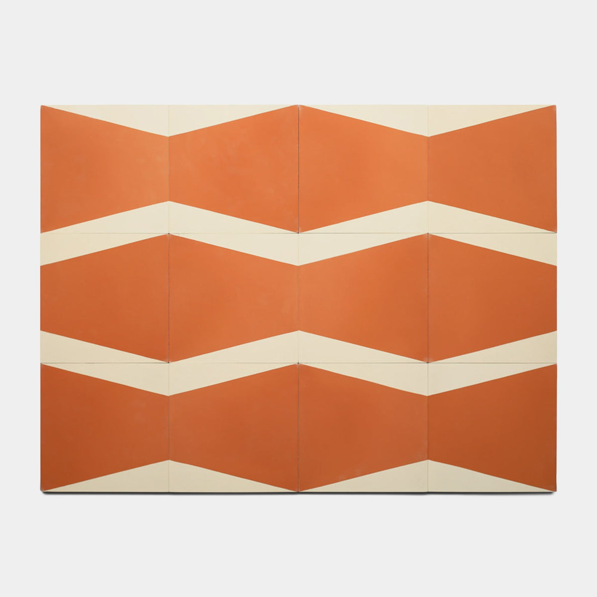 The Sparrow Rust 8x8 Sample by Zia Tile features orange and cream tiles in a geometric grid with zigzag chevron stripes, creating a striking surface design.