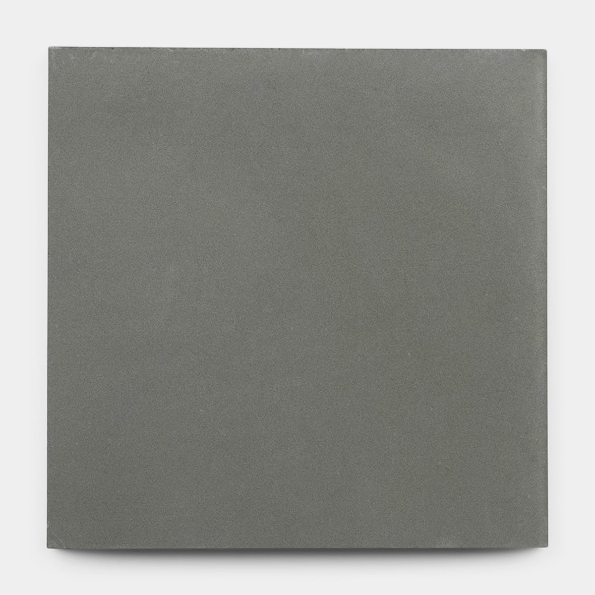 A sample of Zia Tile’s Rust 8x8 tile features a single square, matte gray surface with a smooth, solid finish, styled against a plain white background.