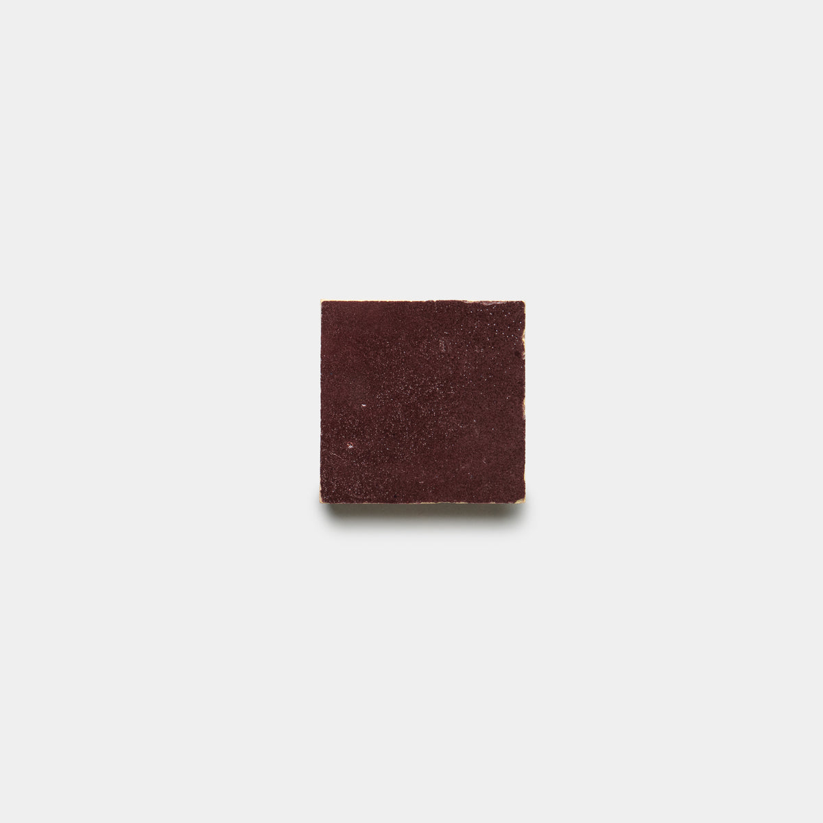 A single Sumac 2x2 tile by Zia Tile, in a dark reddish-brown hue, is centered against a plain white background.