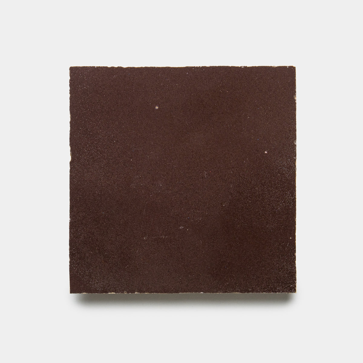 The Sumac 4x4 by Zia Tile is a square, dark brown ceramic tile with a matte finish, shown against a plain white background.