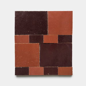 The Xylem 1 tiles by Zia Tile feature a square layout of red and dark brown rectangular and square tiles, creating a striking geometric pattern on a light gray background.