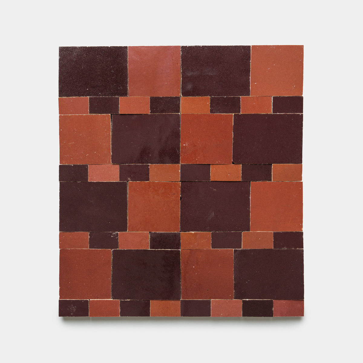 Xylem 1 by Zia Tile features a square layout of glossy red and dark burgundy rectangular tiles arranged in a geometric, alternating pattern on a light background.