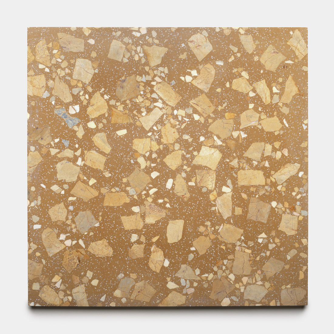 The Sunmor 24x24 by Zia Tile is a square tile with a brown base and irregular light beige and cream stone-like fragments, resulting in a speckled terrazzo pattern.
