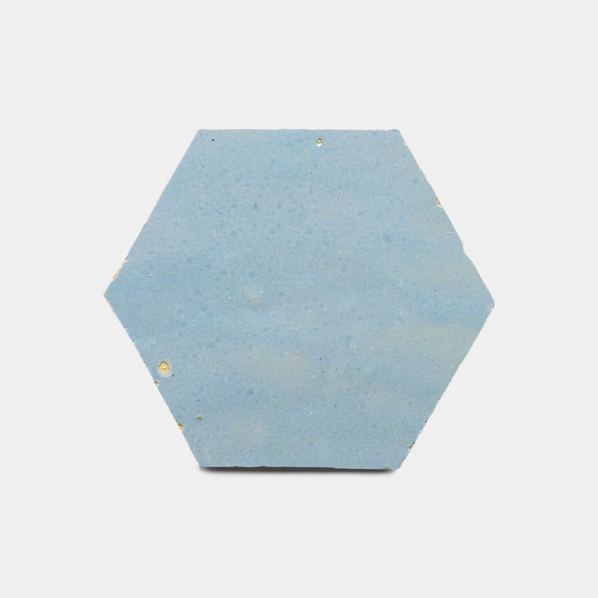 The Superior Blue 2x6 tile sample by Zia Tile is a handmade, light blue hexagon with a smooth surface and subtle gold specks, shown on a plain white background.