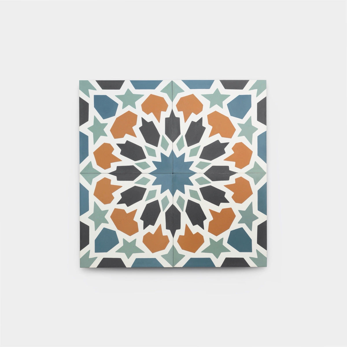 The Tangier 4x4 tile sample by vendor-unknown is a handmade square tile with a detailed geometric design in blue, teal, black, orange, and white, forming an eight-pointed star and repeating motifs on a white background.