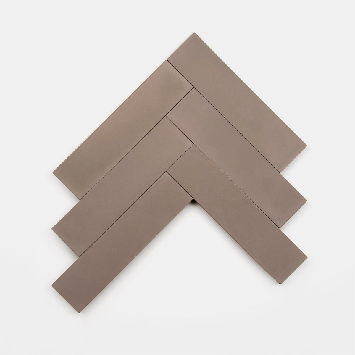 Five rectangular Taupe 2x8 tiles by vendor-unknown are arranged in a herringbone pattern on a white background.