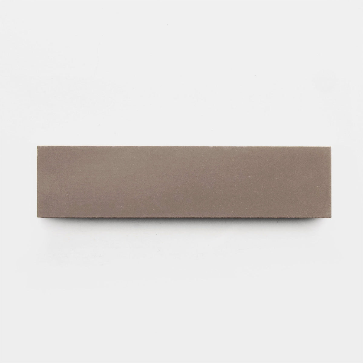 The Taupe 2x8 sample by vendor-unknown lies on a plain white background, its rectangular shape and earthy brown hue reminiscent of handmade tile.