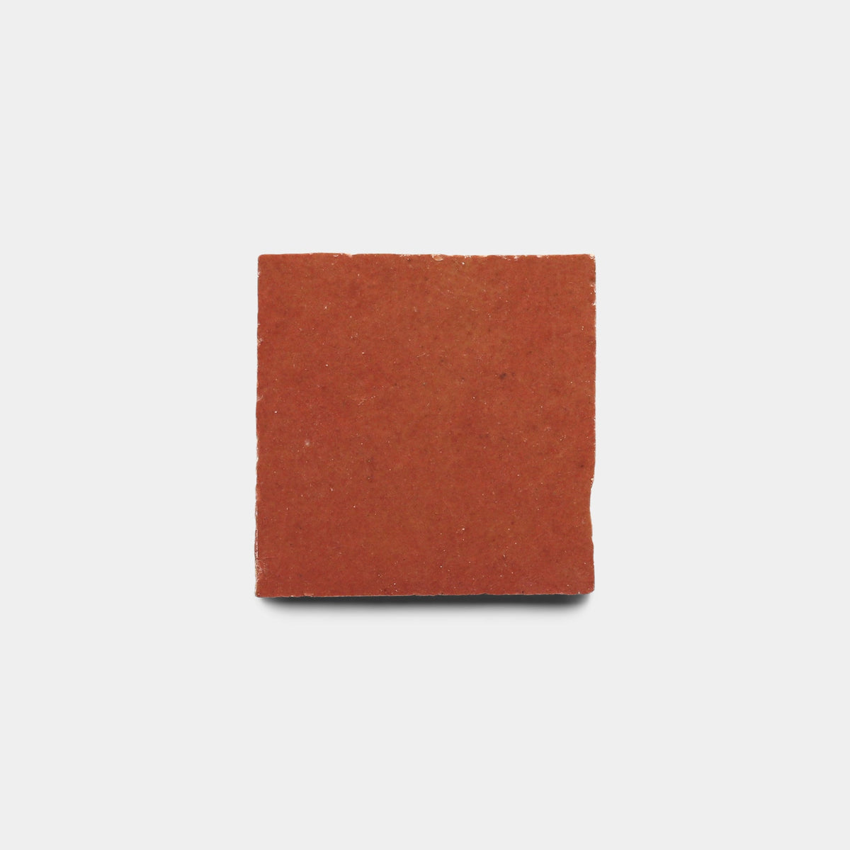 A single Terra Rosa 2x2 sample tile by Zia Tile, made of handmade red clay and square in shape, is centered on a plain white background.