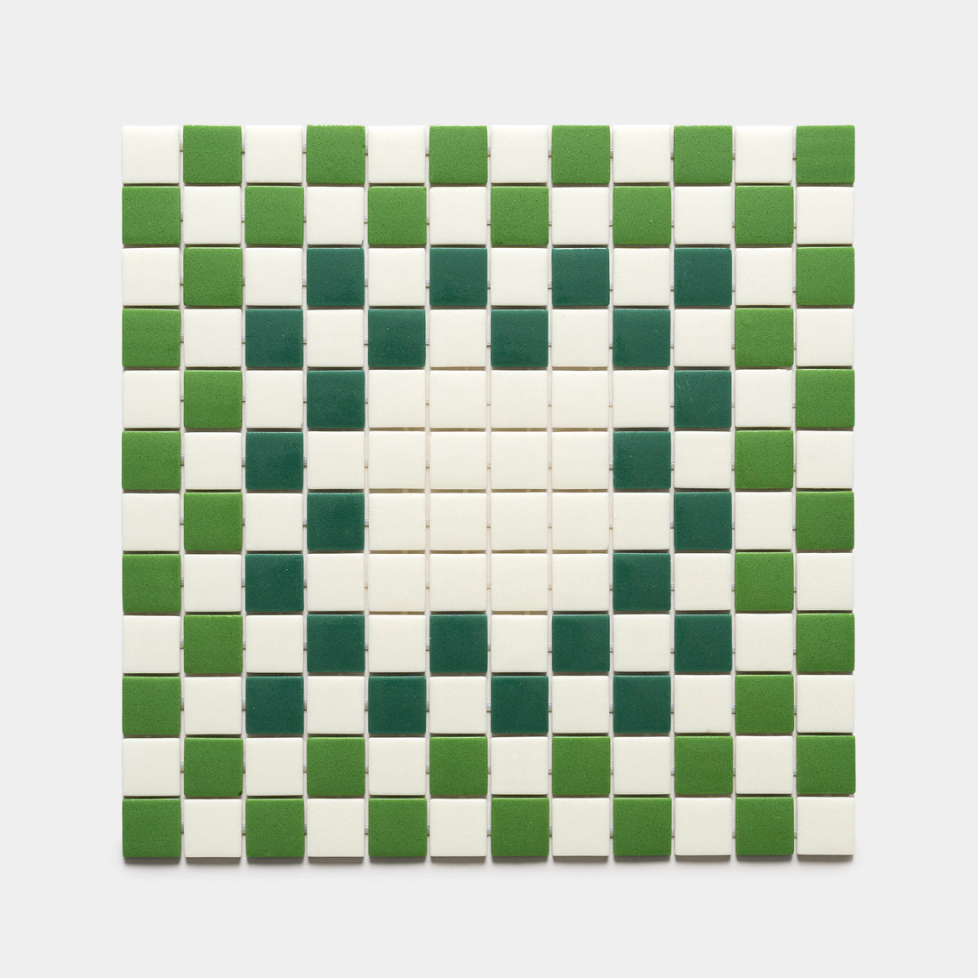 The Tesserae Milk + Clover + Jasper sample by Zia Tile features a square grid of tiles in alternating green and white, forming a central diamond motif on a plain light gray background.