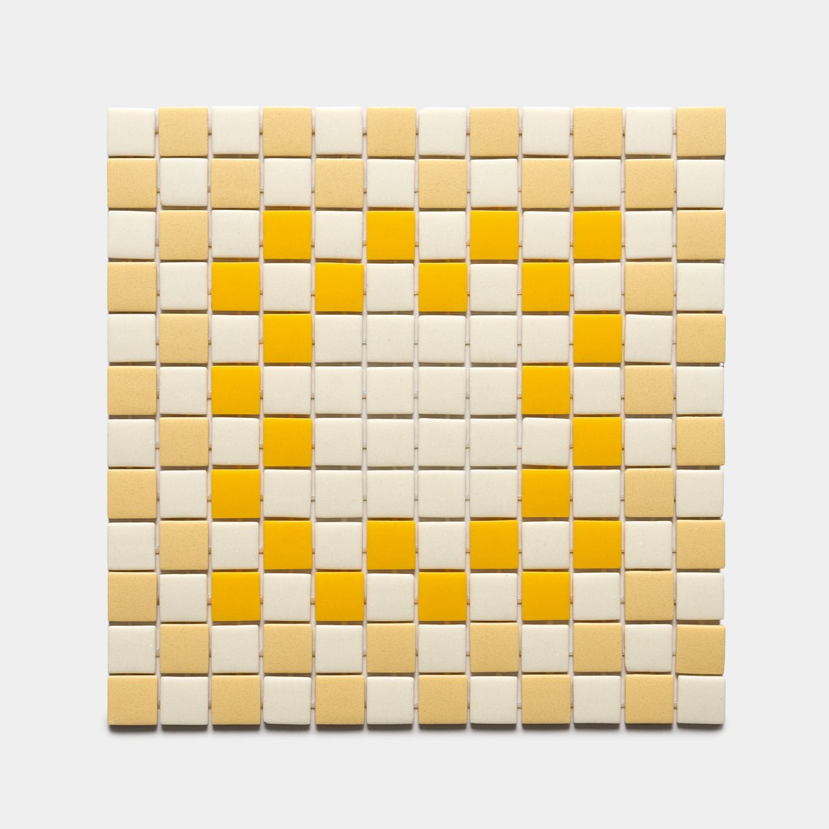 A grid of Zia Tile’s Tesserae Sesame, Buttercup, and Canary tiles forms a heart shape in yellow shades on a light background. Sample available.