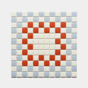 The Zia Tile Tesserae Milk + Tranquil Blue + Roma sample features a red heart made from mosaic squares, surrounded by white and light blue tiles in a grid pattern on a plain background.