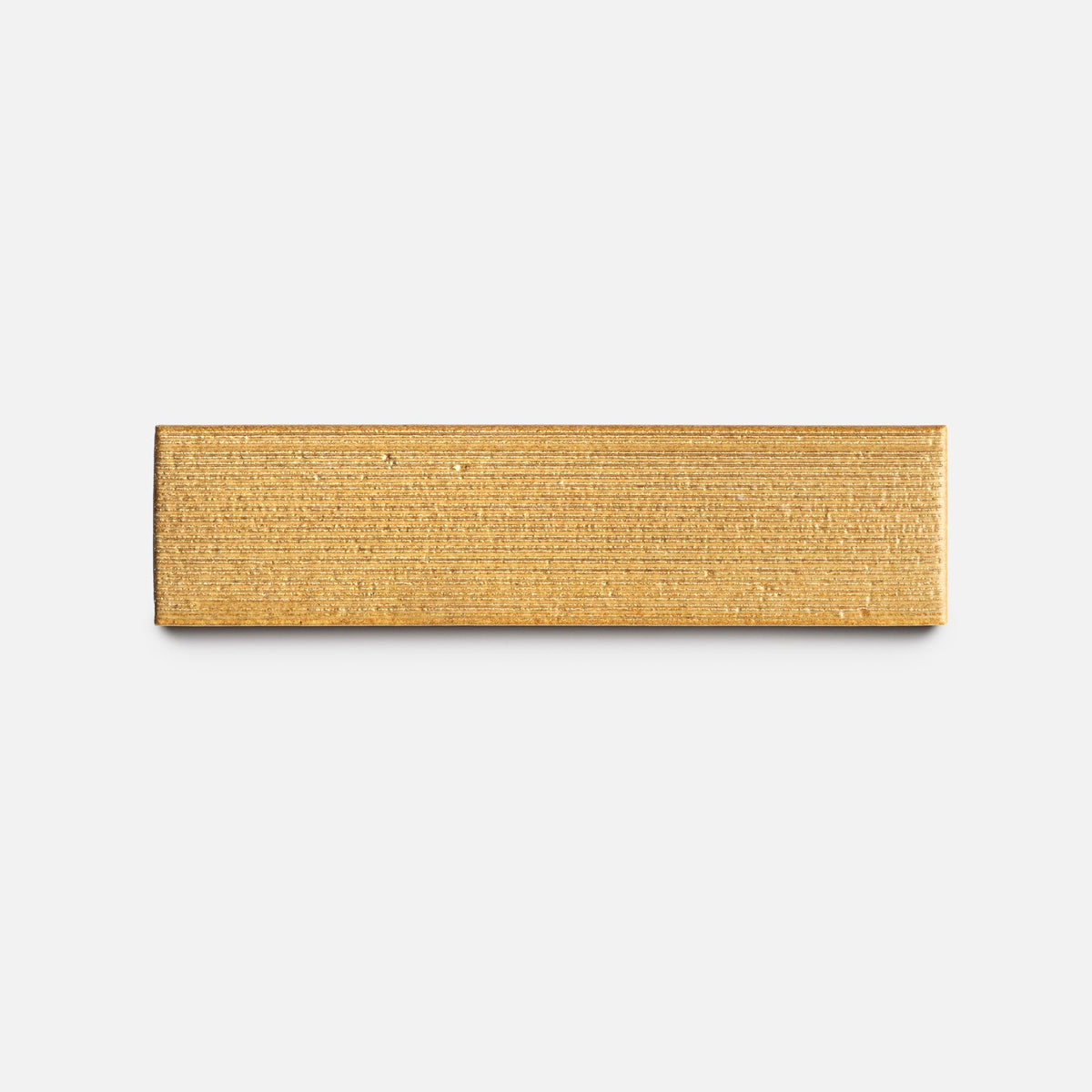 The Toast + Etched, Sample by Zia Tile is a rectangular gold metal bar featuring a horizontal textured pattern, displayed on a plain white background.