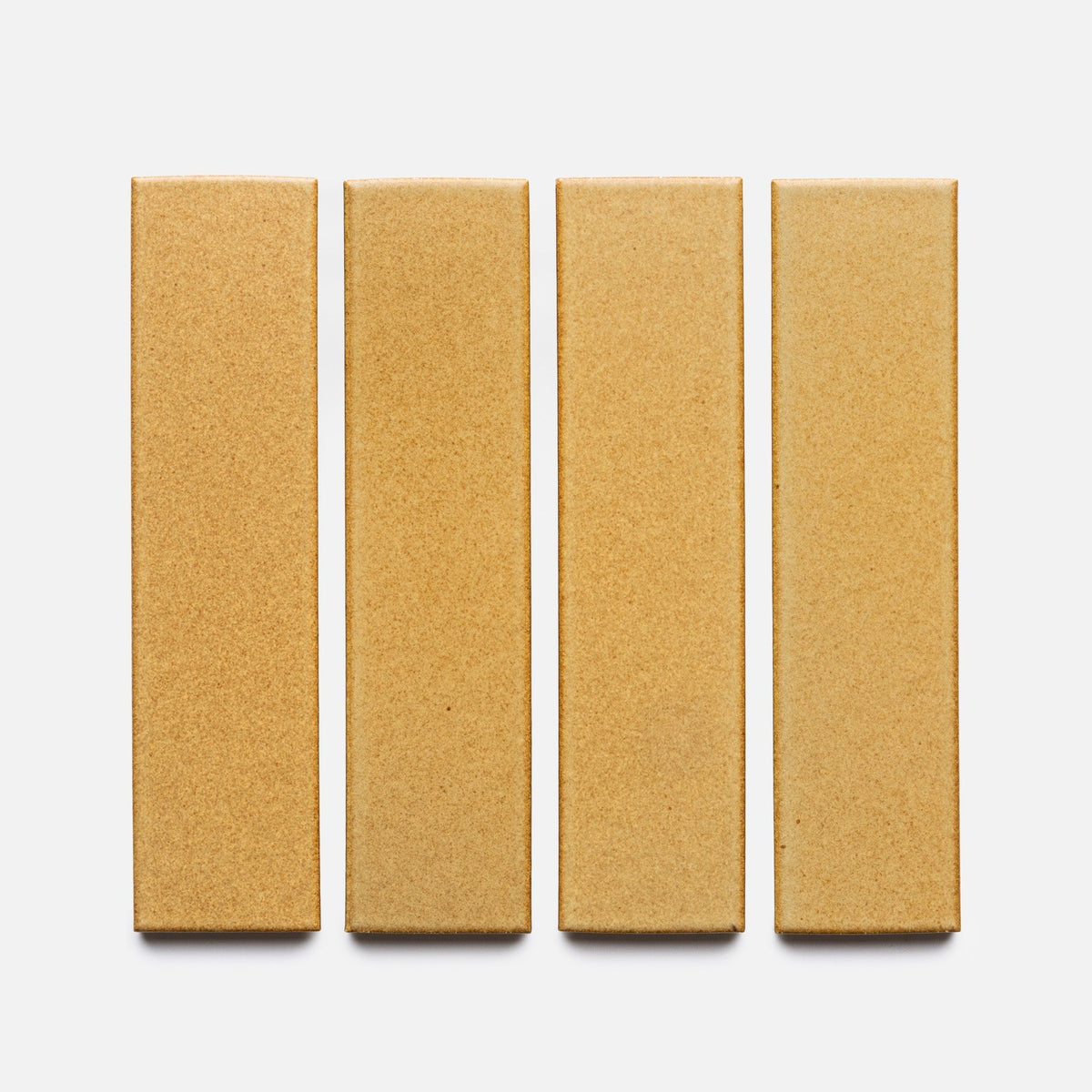 Four rectangular, light brown Toast + Flat, Sample tiles from Zia Tile are arranged vertically in a row on a plain white background.