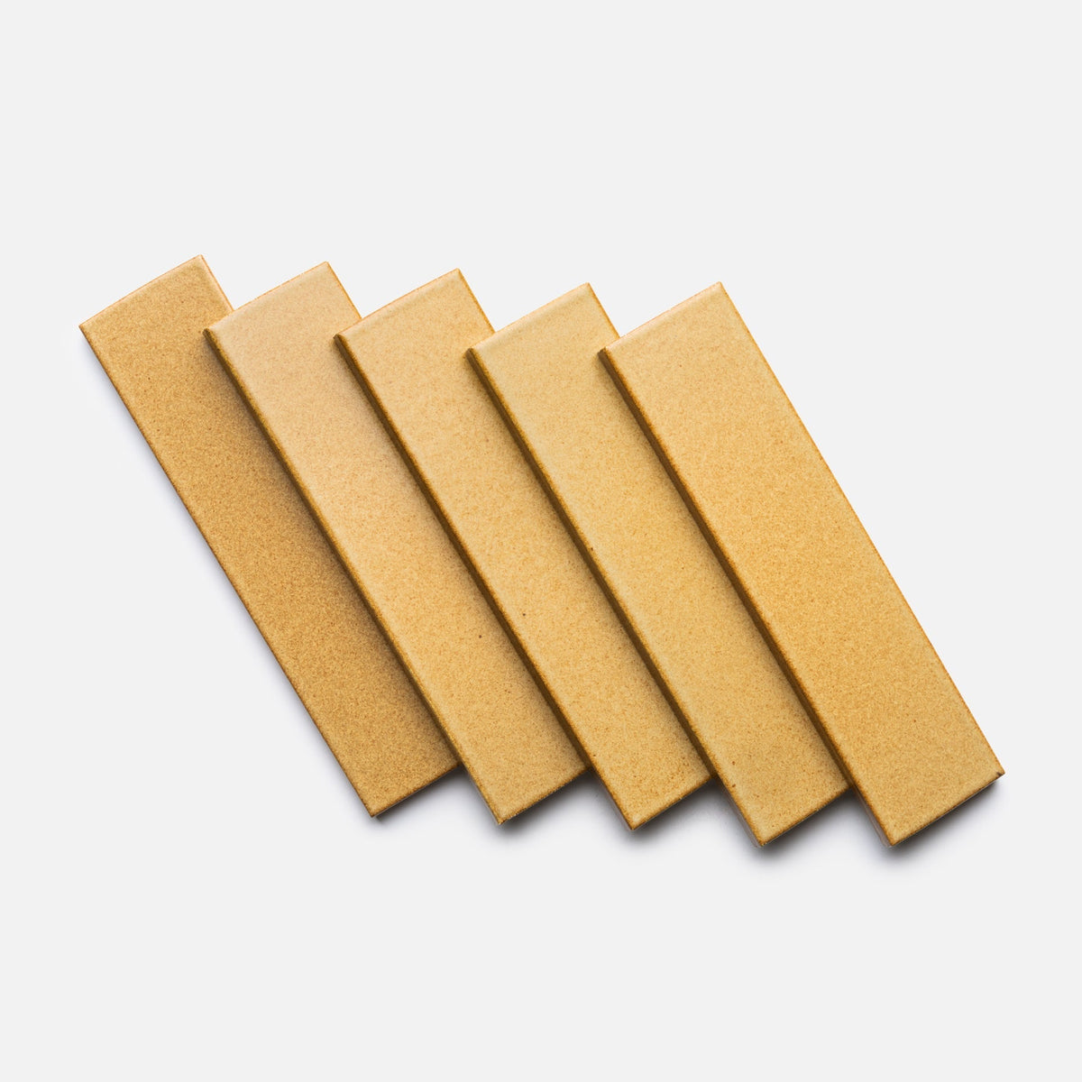 Five Toast + Flat samples from Zia Tile, in rectangular mustard-yellow ceramic, are arranged diagonally and neatly overlapping on a plain white background.