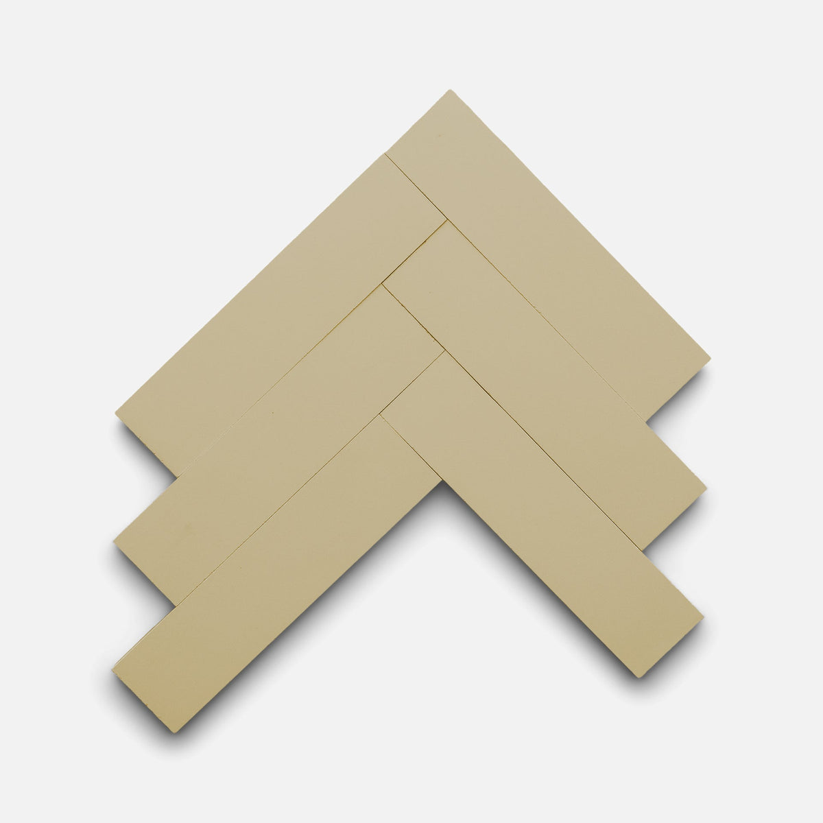 Four Truffle 2x8 tiles by Zia Tile are arranged in a herringbone pattern on a white background, forming a zigzag design with overlapping edges and visible shadows.