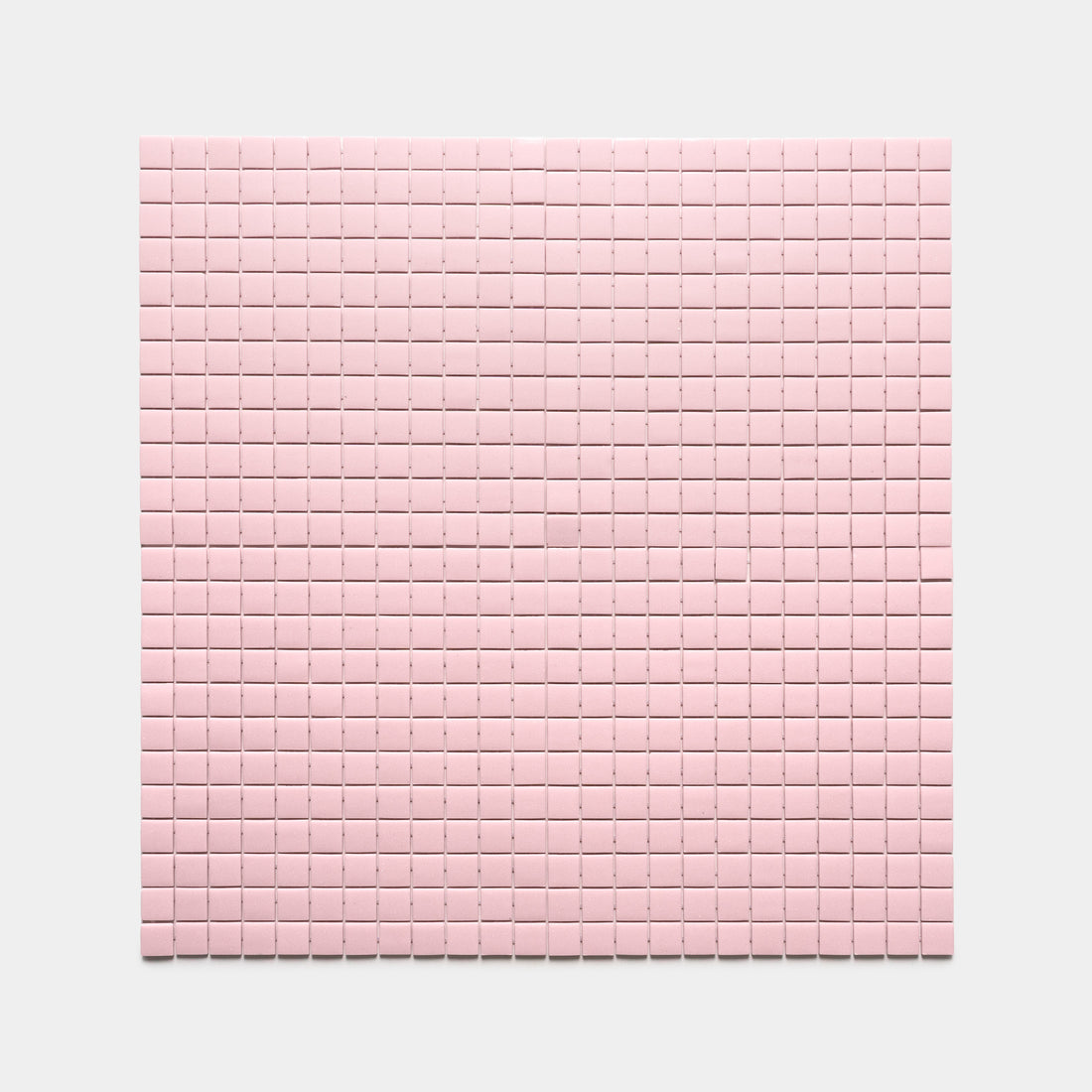 A grid of evenly spaced Tulip 1x1 pink tiles from Zia Tile is arranged on a flat surface against a plain light gray background.