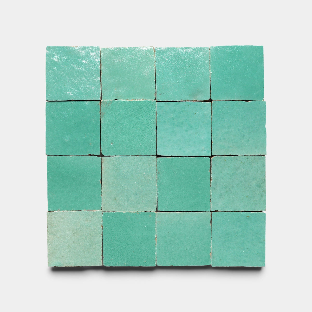 A 4x4 grid of sixteen Tulum 2x2 Sample ceramic tiles by Zia Tile, featuring a turquoise glossy finish, displayed neatly aligned against a plain white background.