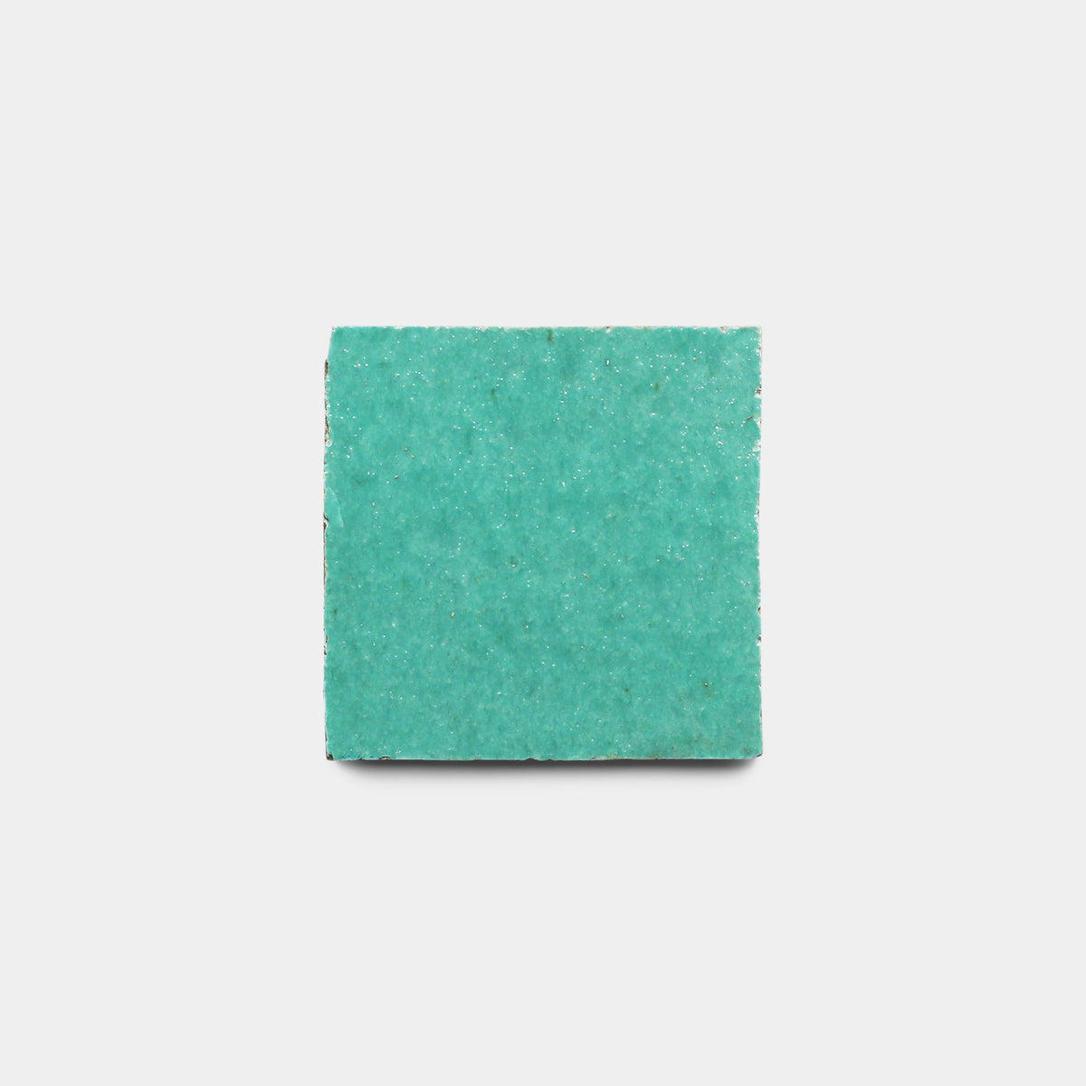 A single turquoise Tulum 2x2 tile sample from Zia Tile is centered on a plain white background, resembling a handmade tile.