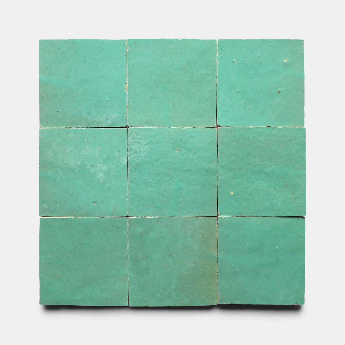 Nine Tulum 2x2 handmade tiles by Zia Tile, arranged in a three-by-three grid on a plain white background. The tiles display slightly uneven surfaces and subtle color variations.