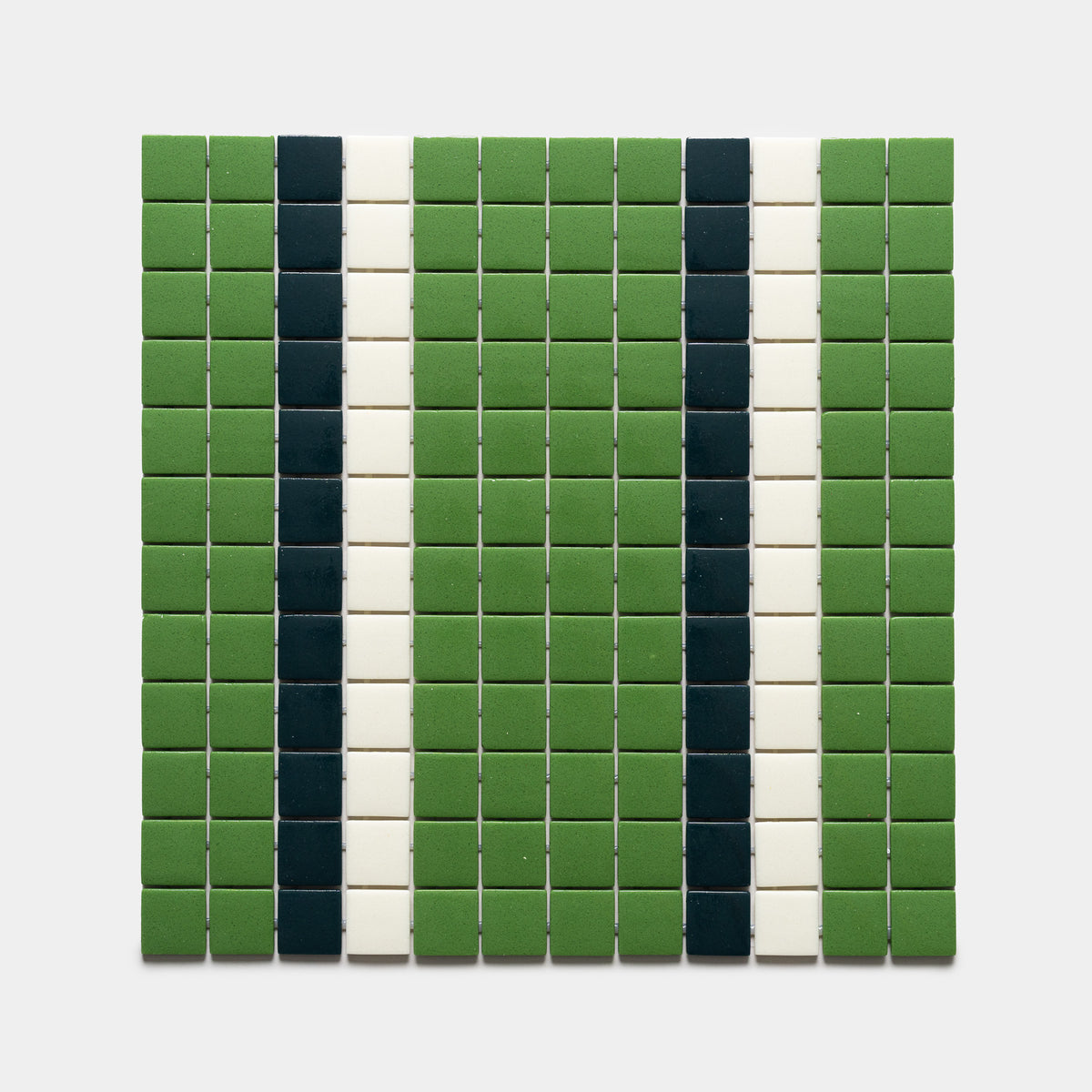 A grid of Union Clover + Vespertine + Milk tiles from Zia Tile forms vertical stripes: green on the sides, two black, and two narrow white stripes in the center, set against a light gray background.