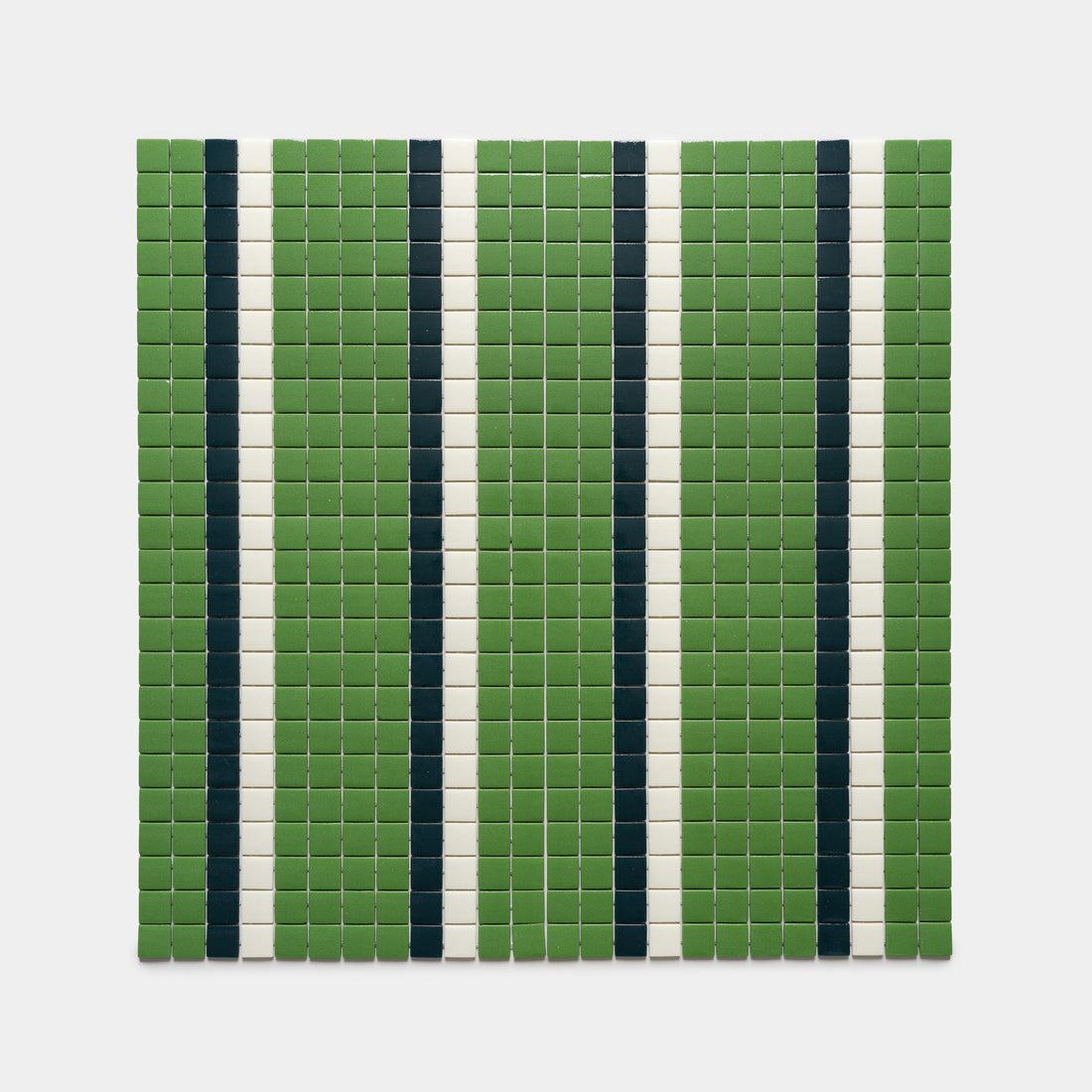 A grid of small square tiles by Zia Tile, featuring the Union Clover, Vespertine, and Milk designs in alternating vertical stripes of green, dark blue, and white on a white background.