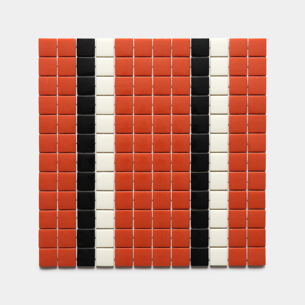 A rectangular grid of mostly red tiles with two vertical black stripes and two vertical white stripes on light gray, featuring Union Roma + Jet Black + Milk, Sample by Zia Tile.