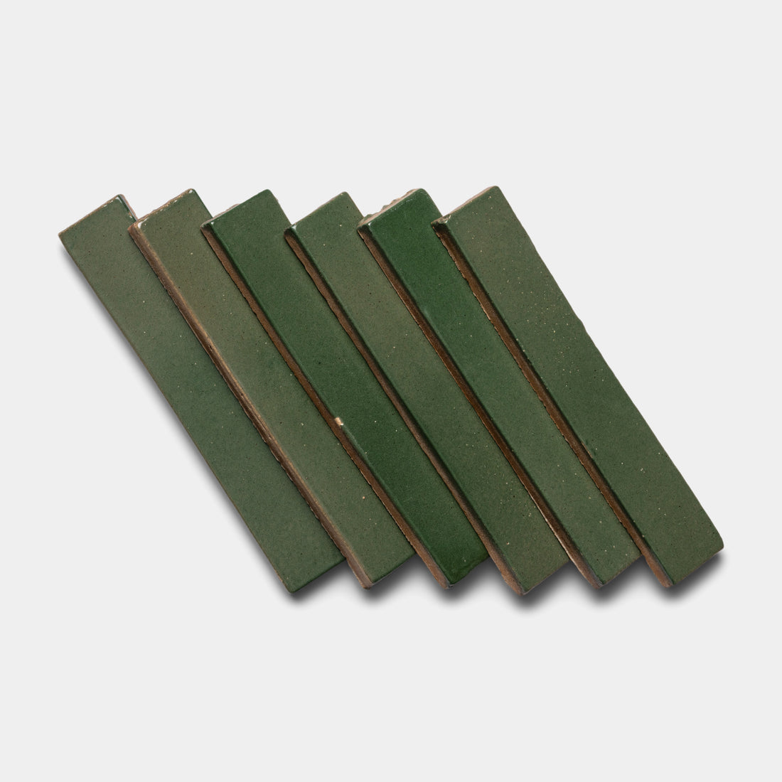 Six Valverde Mini Bar tiles by Zia Tile, in green ceramic, are arranged slightly diagonally and overlapping against a plain white background.