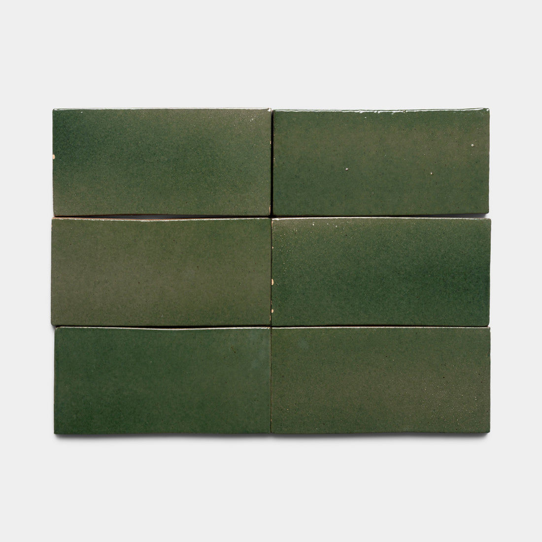Six Valverde 4x8 Rectangle tiles by Zia Tile, featuring a glossy green finish with subtle color variations and slightly uneven surfaces, are arranged in two rows of three on a light gray background.