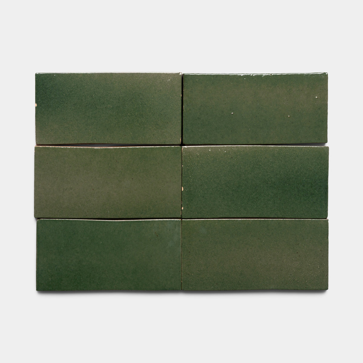 Six Valverde 4x8 Rectangle tiles by Zia Tile, featuring a glossy green finish with subtle color variations and slightly uneven surfaces, are arranged in two rows of three on a light gray background.