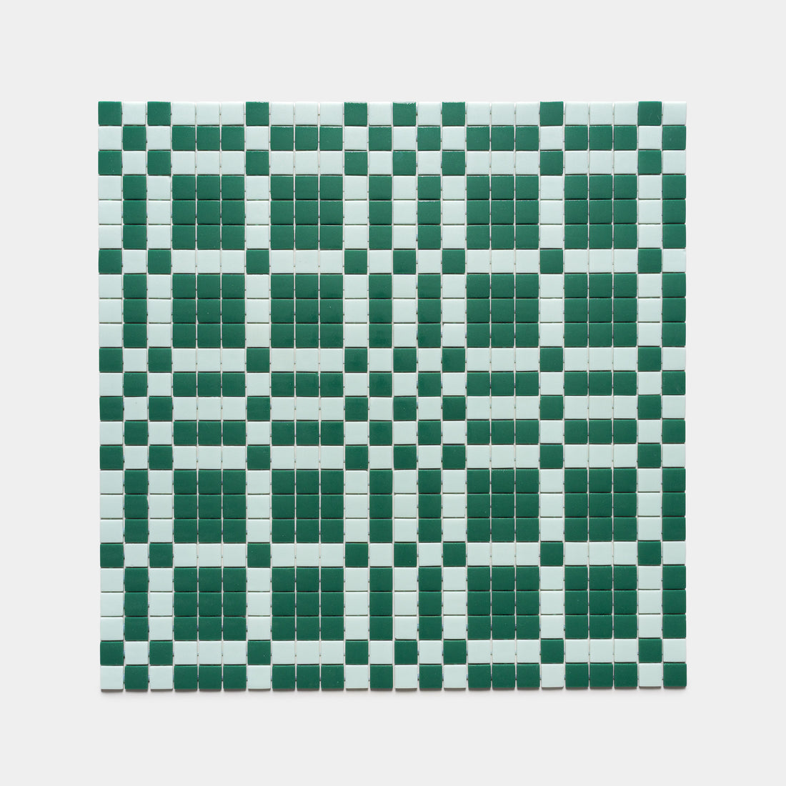 The Vaso Jasper + Piscine tiles by Zia Tile feature a precise, geometric grid of small green and white squares, forming checkered patterns with larger squares and rectangles against a clean white background.