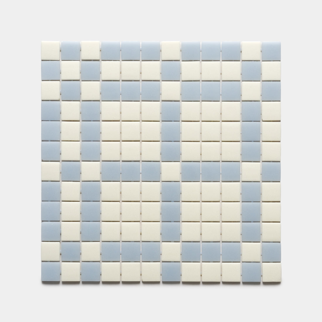 The Vaso Milk + Tranquil Blue sample by Zia Tile features small square tiles in alternating vertical stripes of light blue and off-white on a plain, light gray background.