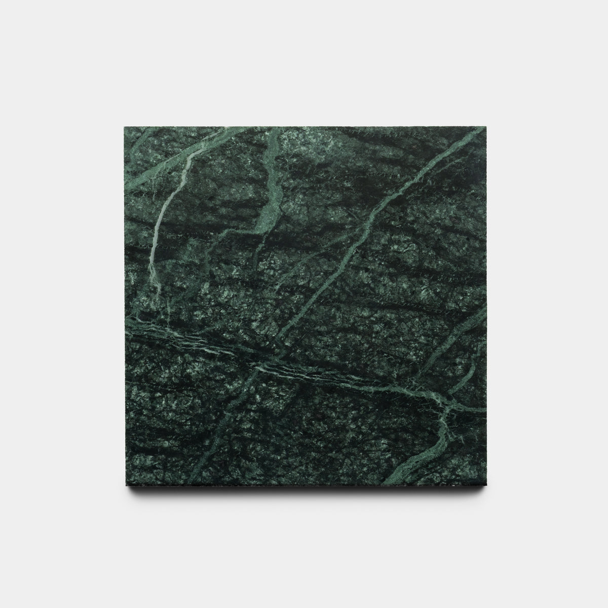 The Verde Alpi 6x6 sample by Zia Tile is a square slab of dark green marble with lighter green and white diagonal veins, shown against a plain white background.