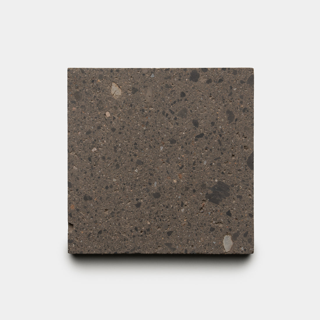 A square sample of Zia Tile’s Volcan 6x6, a dark, speckled concrete tile with small aggregate for a natural stone look, is displayed against a plain white background.