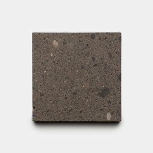 A square sample of Zia Tile’s Volcan 6x6, a dark, speckled concrete tile with small aggregate for a natural stone look, is displayed against a plain white background.