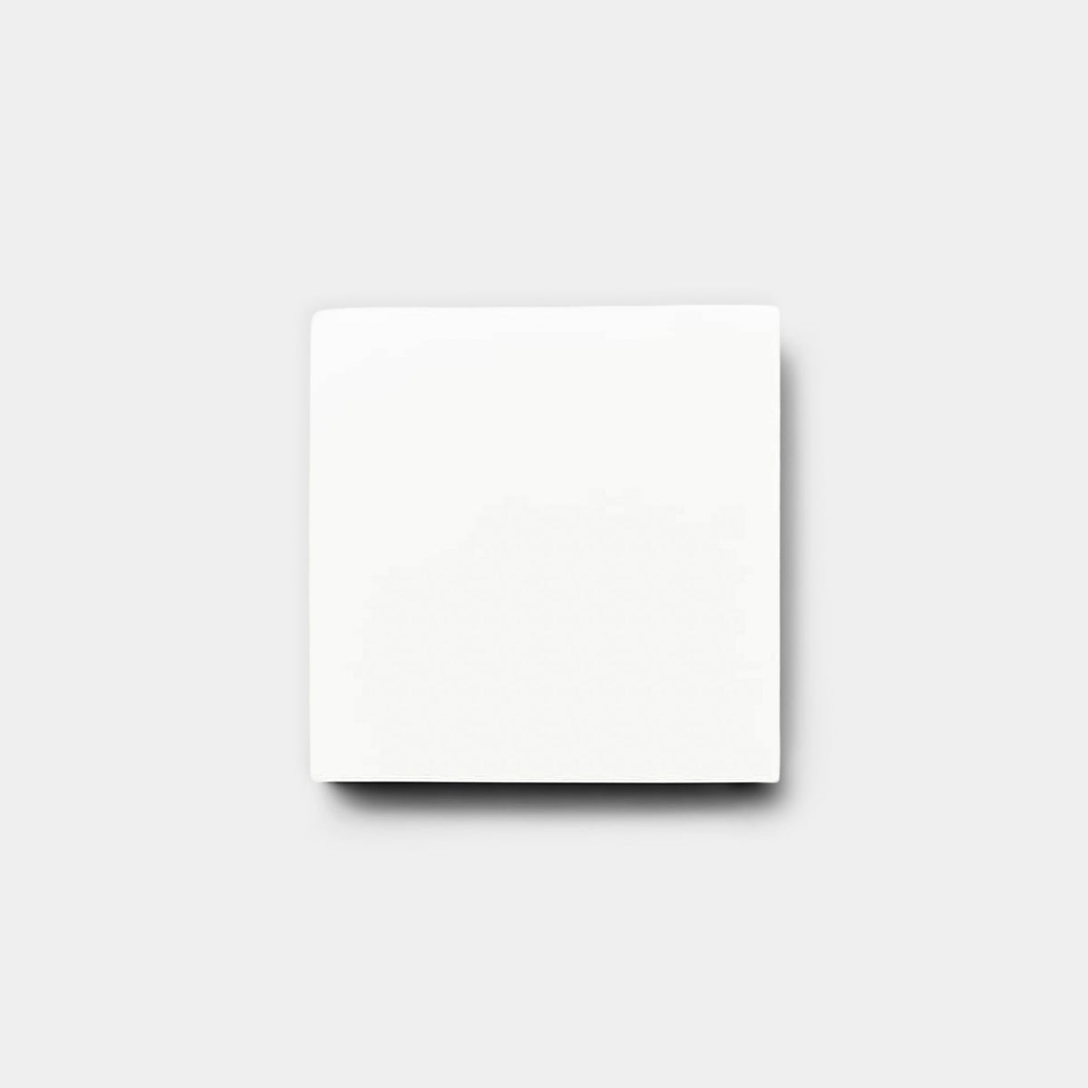 A White 4x4 tile sample from vendor-unknown is centered on a light gray background, casting a subtle shadow below.