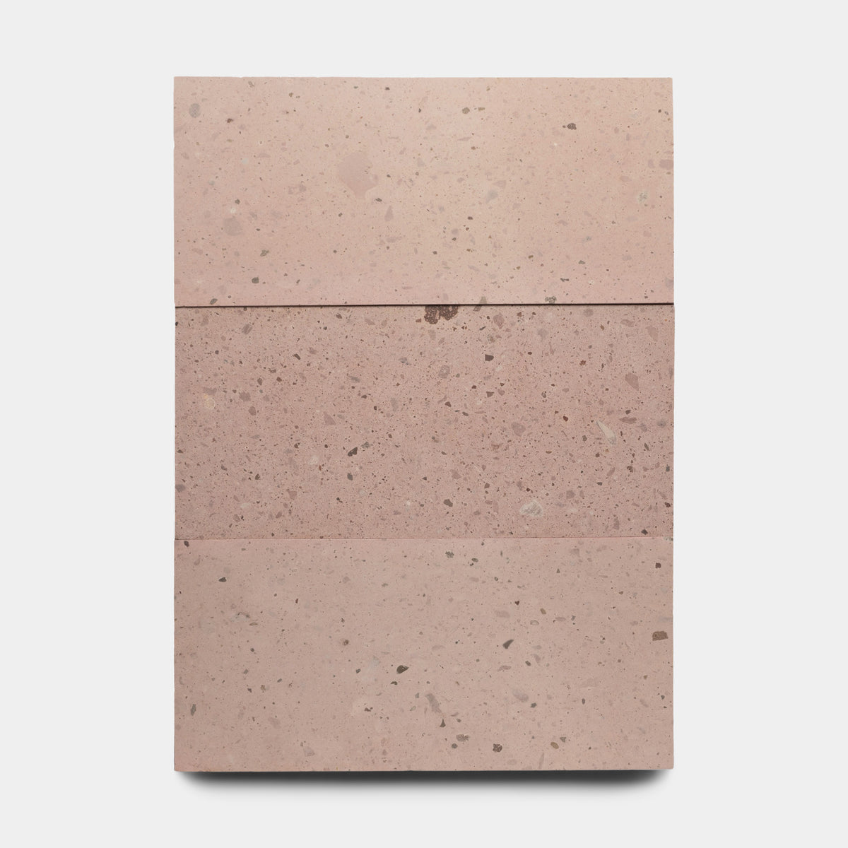 The Yuma 12x24 by Zia Tile is a rectangular pinkish Mexican Cantera slab with natural speckles and subtle color variation, divided horizontally into three sections by faint lines, set against a plain white background.