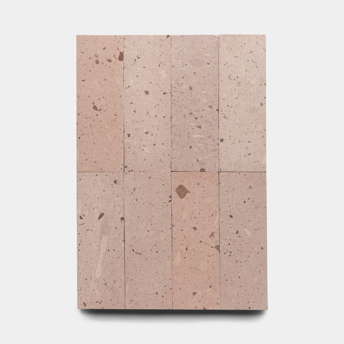 Nine Yuma 4x12 terrazzo tiles by Zia Tile, in light pink with small brown and beige stone flecks, are arranged in a 3x3 grid on a plain white background.