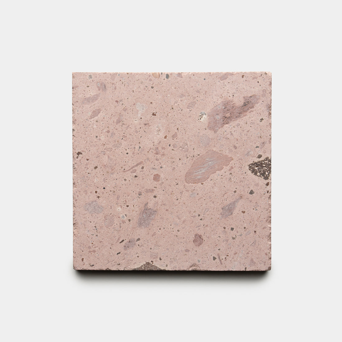The Yuma 6x6 by Zia Tile is a square tile featuring a pinkish hue, rough texture, and specks of lighter and darker colors, displayed on a plain white background.