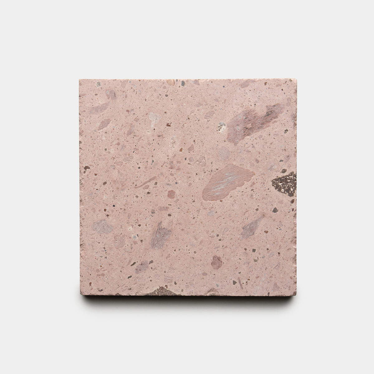 The Yuma 6x6 by Zia Tile is a square tile featuring a pinkish hue, rough texture, and specks of lighter and darker colors, displayed on a plain white background.