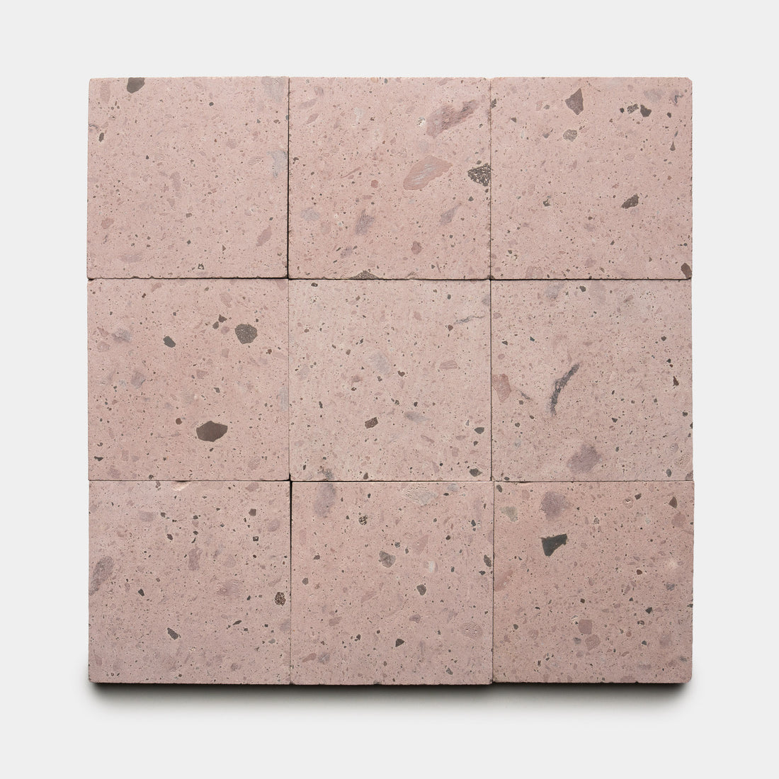 Nine Yuma 6x6 terrazzo tiles by Zia Tile, featuring light pink tones with small dark and light stone fragments, are arranged in a 3x3 grid on a white background.