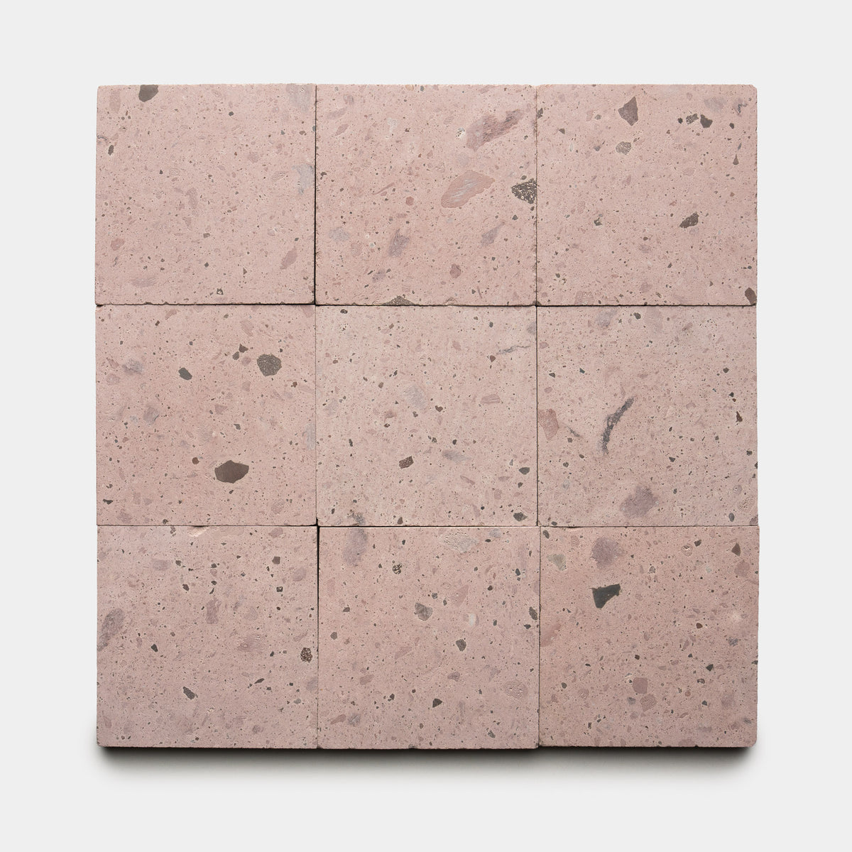 Nine Yuma 6x6 terrazzo tiles by Zia Tile, featuring light pink tones with small dark and light stone fragments, are arranged in a 3x3 grid on a white background.