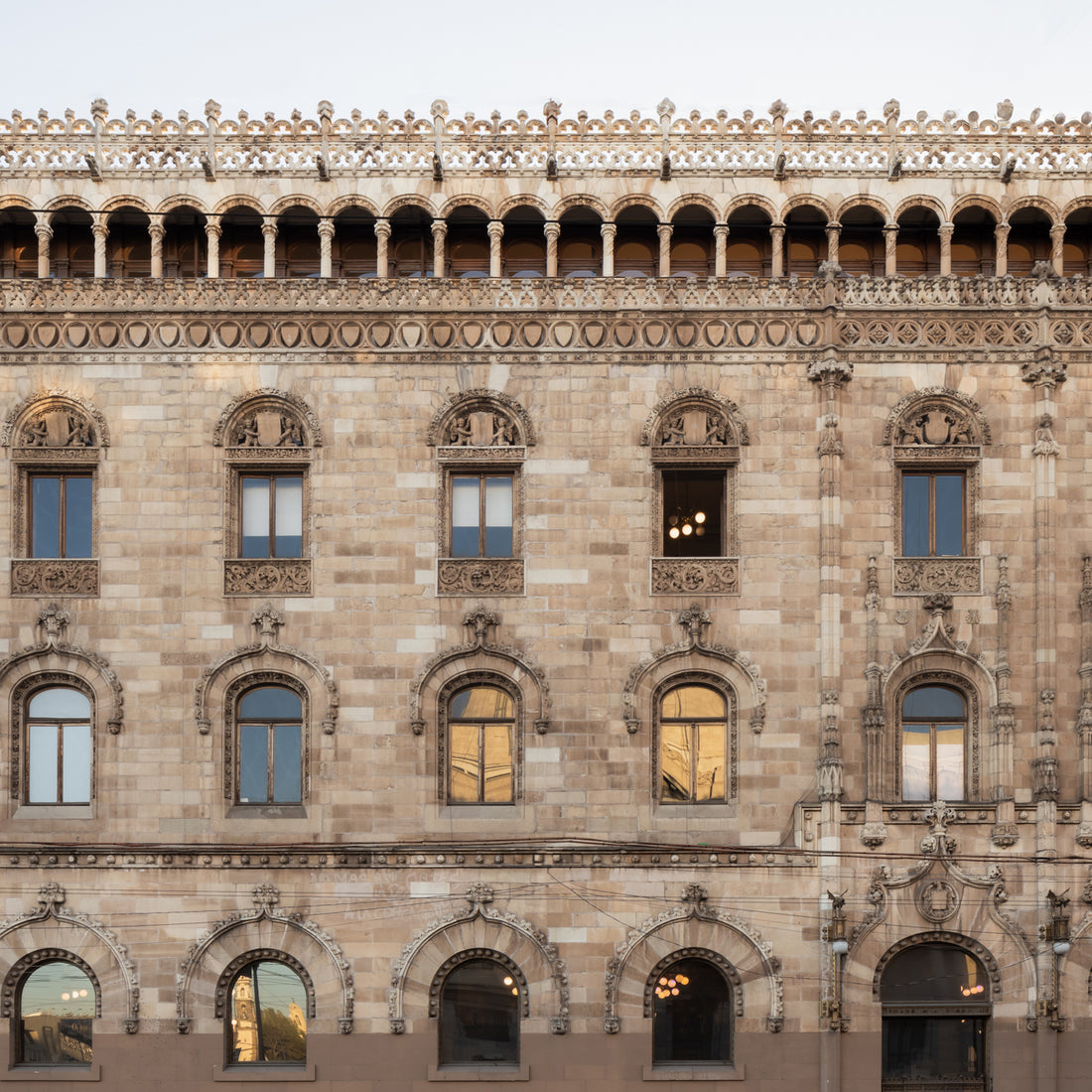 The Sierra 4x12 by Zia Tile features natural volcanic stone in a historic facade design with arched and rectangular windows, intricate carvings, and ornate roofline details inspired by Renaissance and Gothic architecture.