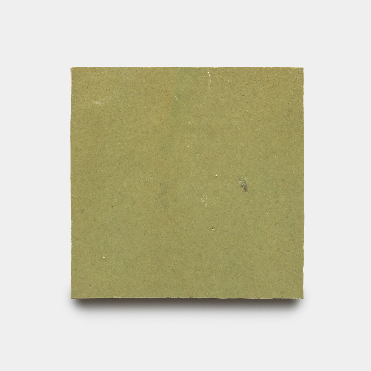 The Za'atar 4x4 by Zia Tile is a plain, square tile in light green paperboard with a slightly rough texture and small imperfections, shown on a white background.